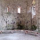 En slottsal med bänkar och stora ljusstakar.