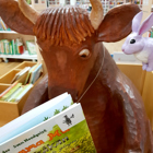 Kaninen lyssnar på Mamma Mu som läser en bok.