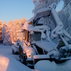 En gul traktor täckt av snö.